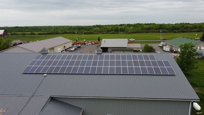 На фото солнечные батареи, установленные на металлической ребристой крыше.